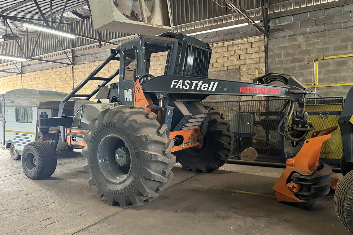 A large black tractor in a warehouse